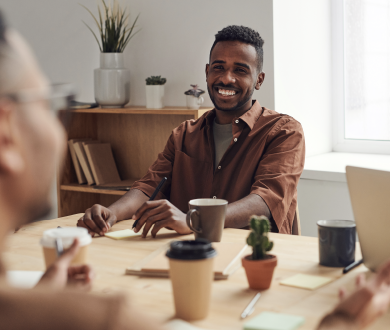 Man seated at table smiling 